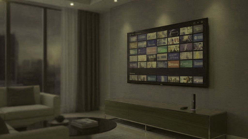 A living-room TV showing an IPTV channel guide with a streaming stick on the console